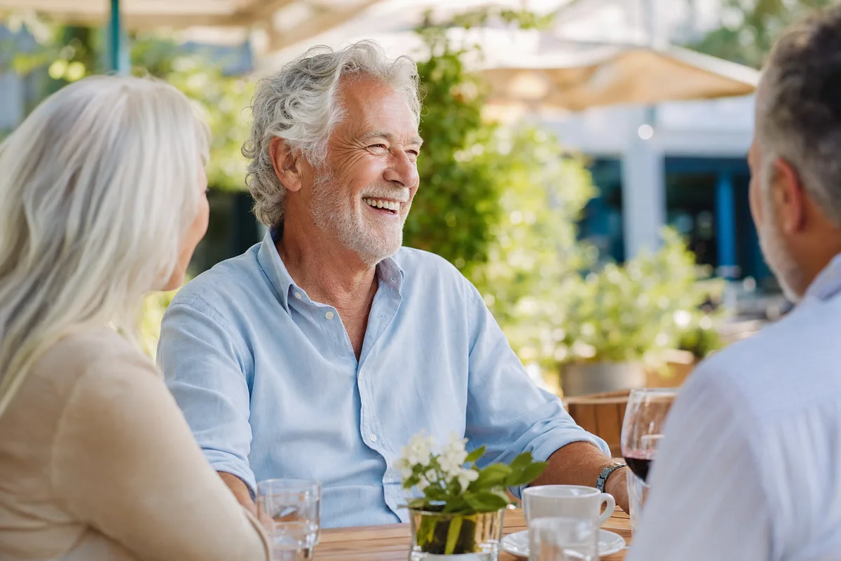 Confident man smiling and enjoying a meal after full mouth rehabilitation in Jerusalem